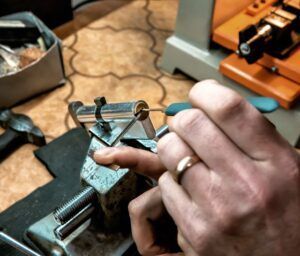 A person wearing a wedding ring is working on a lock.