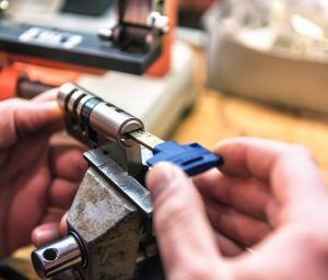 A person is working on a lock with a tool.