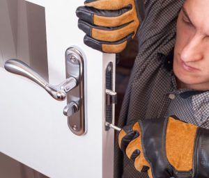 A man is fixing a door with a screwdriver.