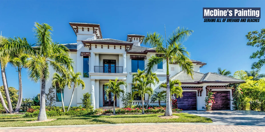 A large white house with palm trees in front of it.