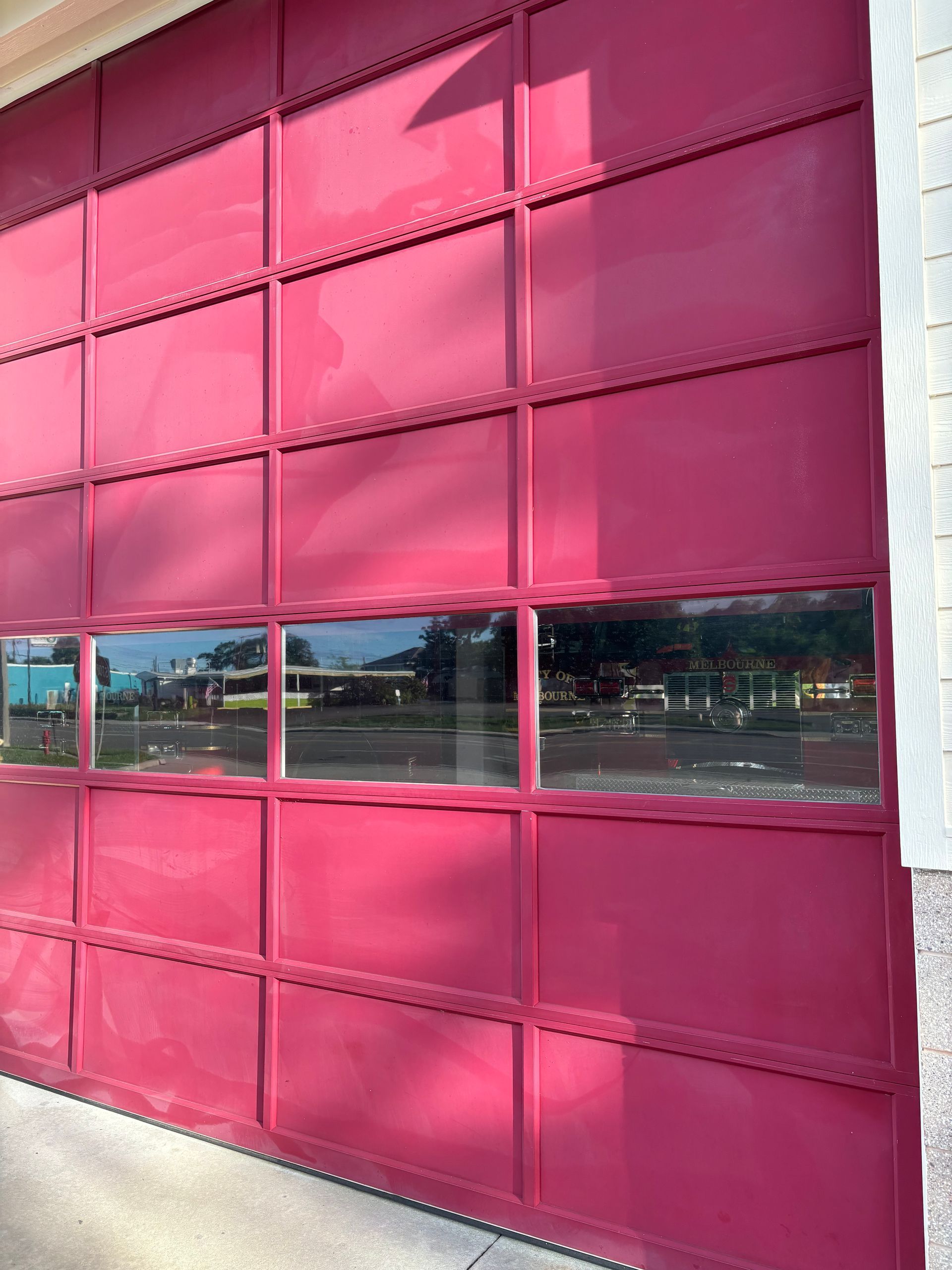 A close up of a pink garage door with a lot of windows.