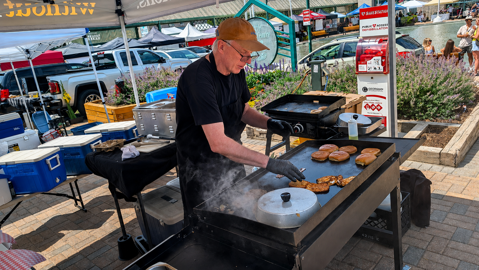 Vendor cooking food on a flat-top grill at an outdoor market stall