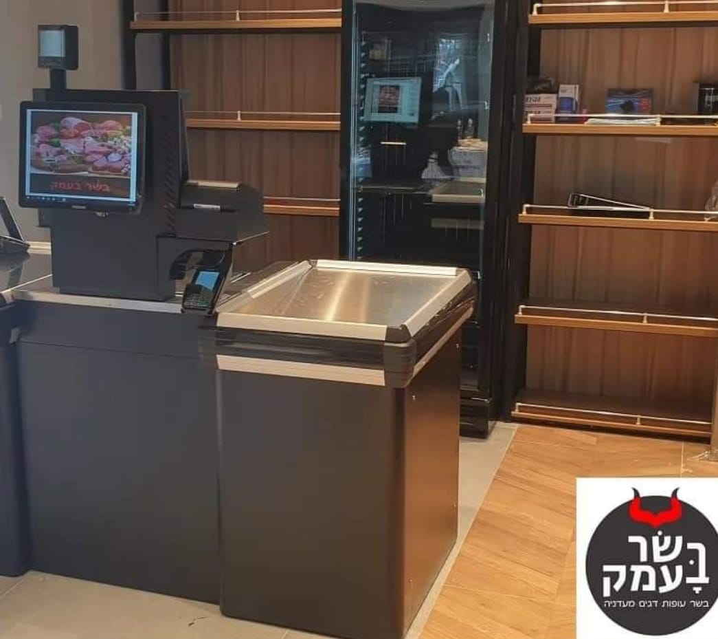 Modern interior with wooden shelves, a black glass fridge, counter, and stainless steel display case in a store.