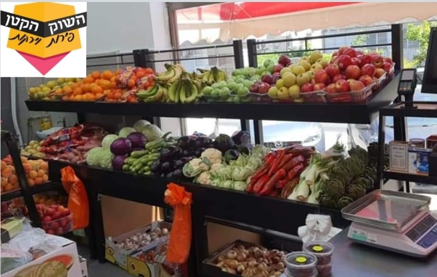 Produce stand with crates of colorful fruits and vegetables, shelves and a scale in a market stall