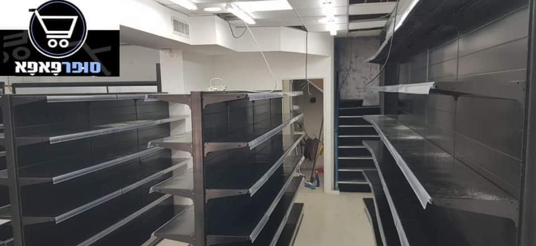 Empty grocery store aisles with metal shelves and fluorescent lighting; store logo in top left.