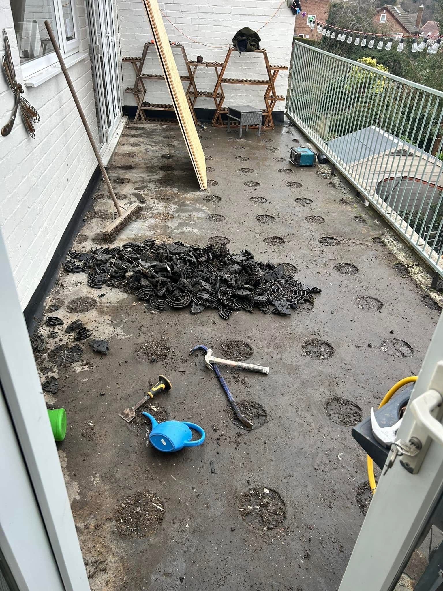 A balcony with a lot of dirt on it and a lot of tools on the floor.