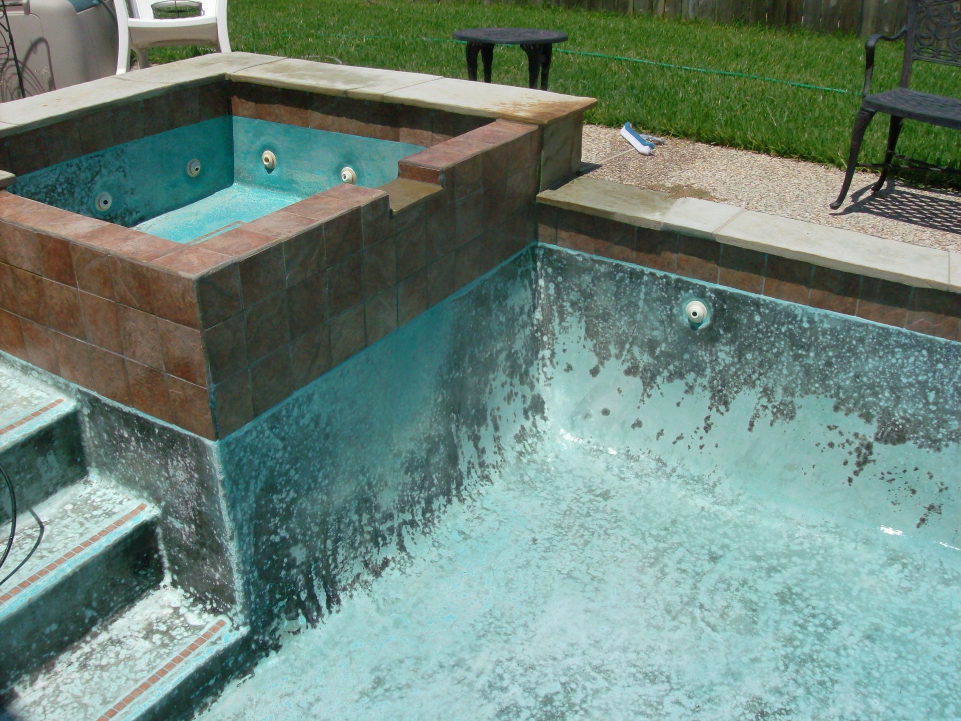 A swimming pool with a jacuzzi in the middle of it