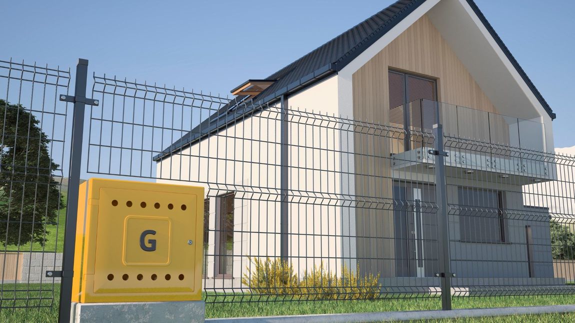 A yellow box with the letter g on it is in front of a house behind a fence.