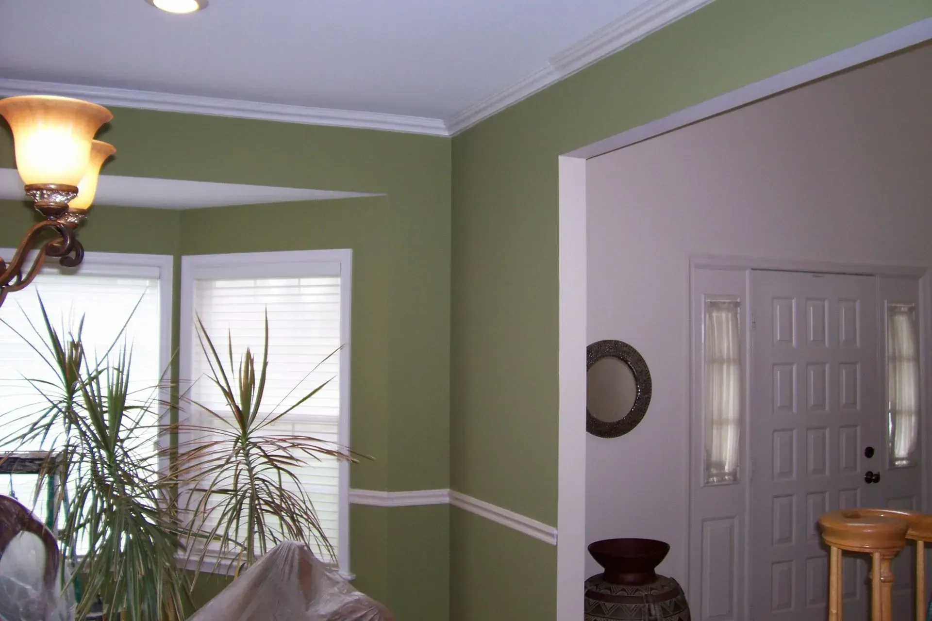 A living room with green walls and white trim