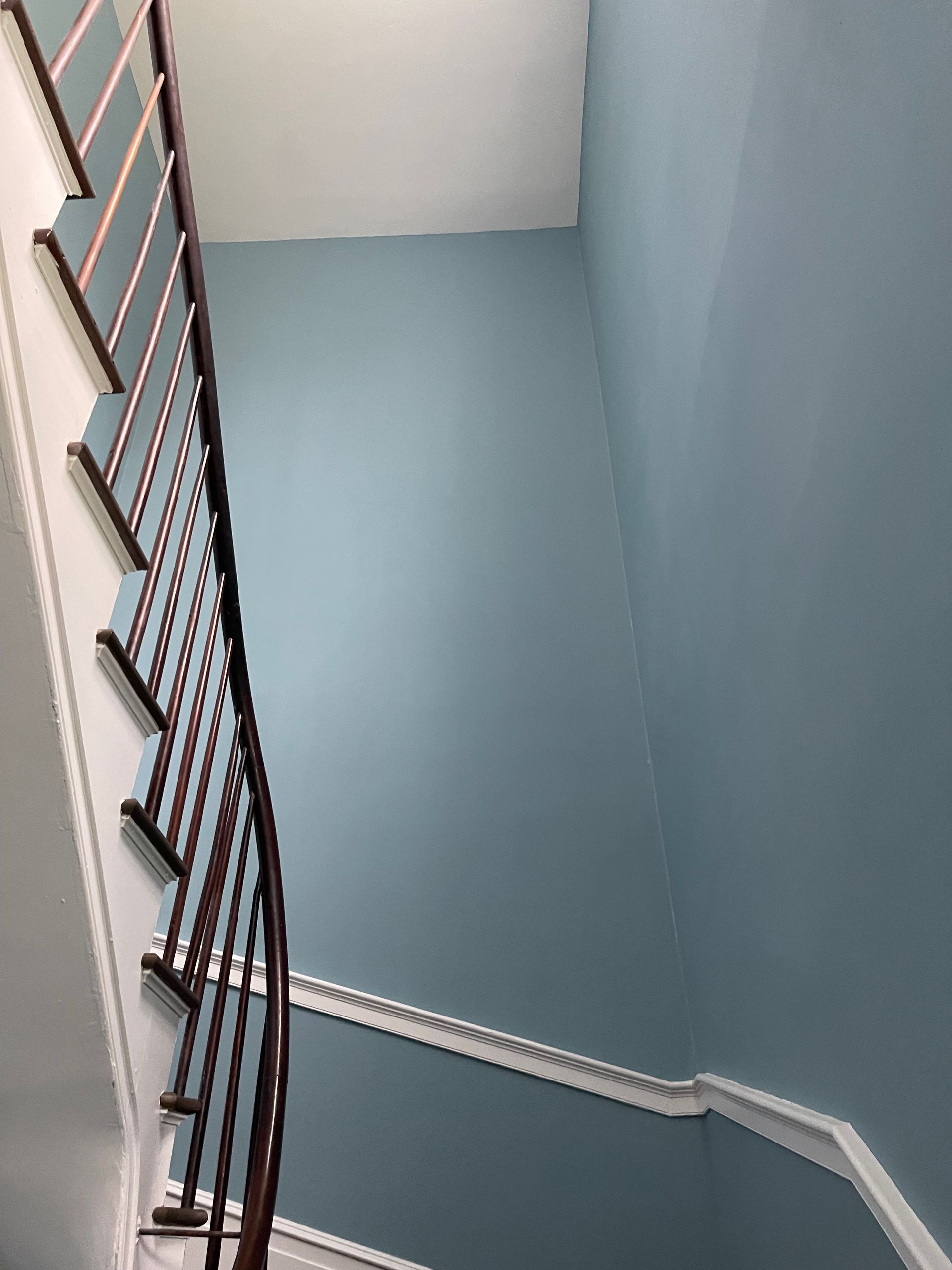 A staircase with blue walls and a wooden railing