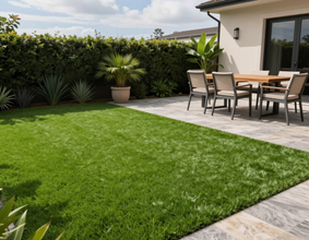 Jardín residencial con pasto sintético alrededor de una terraza