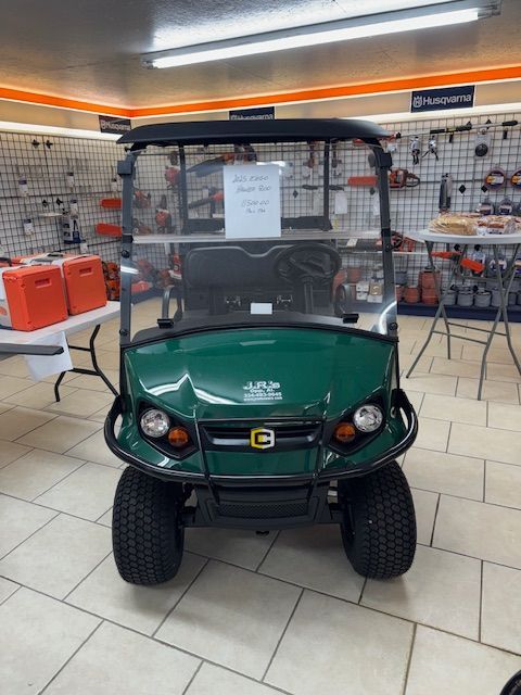 Black utility cart with lifted cargo bed, parked inside a store, showing the vehicle's mechanics and a red tail light.