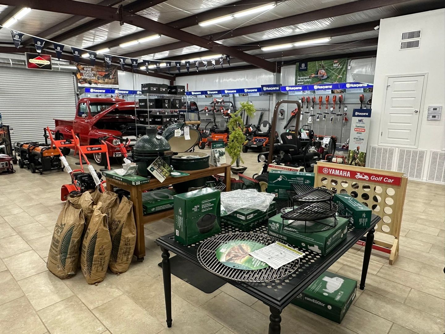 Inside a store, a display of grills and gardening equipment.