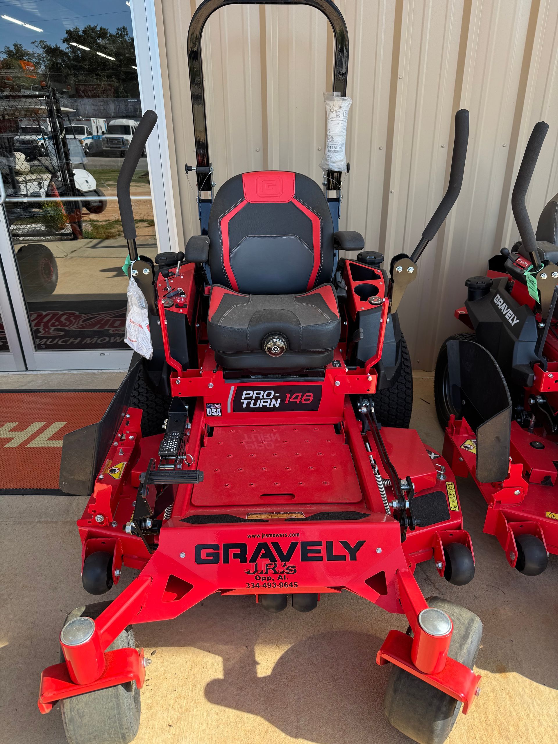Red and black Gravely zero-turn lawn mower on display, angled front view.