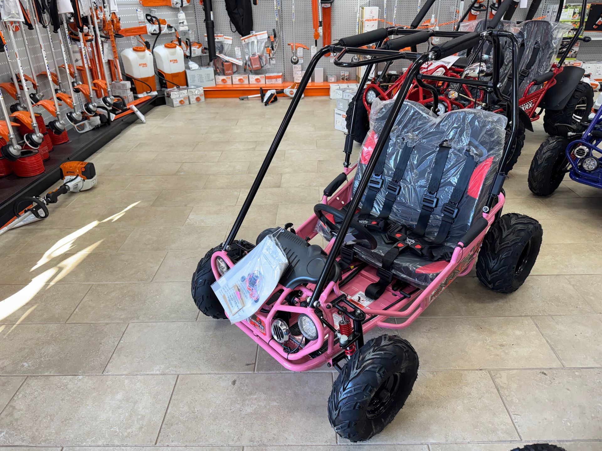 Pink go-kart on display in a store.