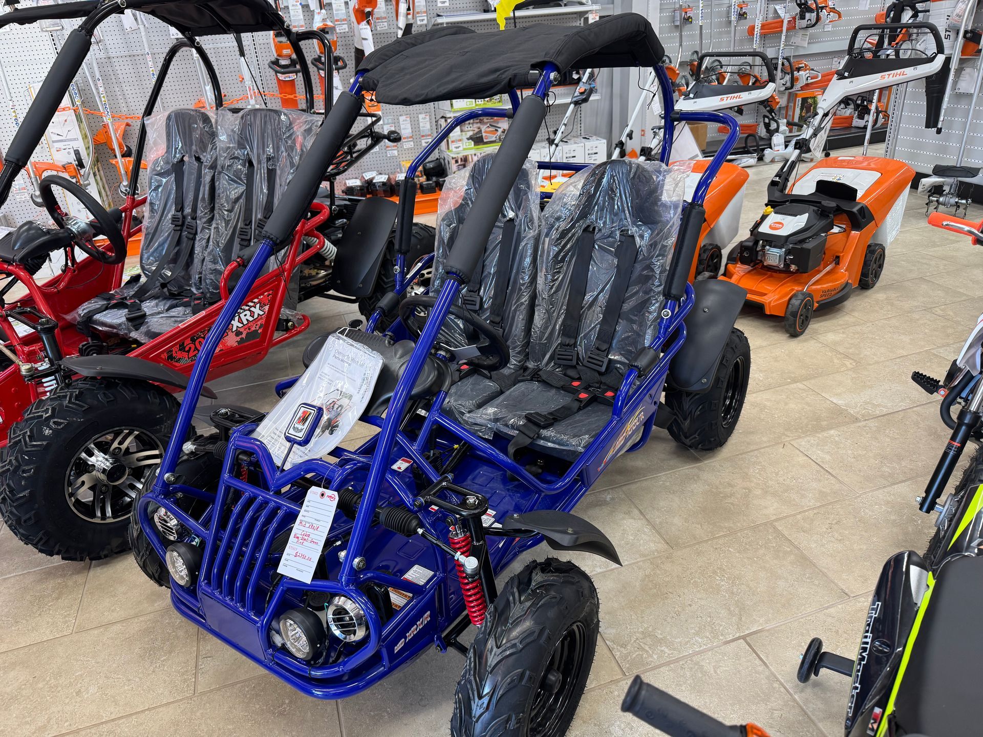 Blue and red go-karts in a store setting, with a black canopy and black tires.