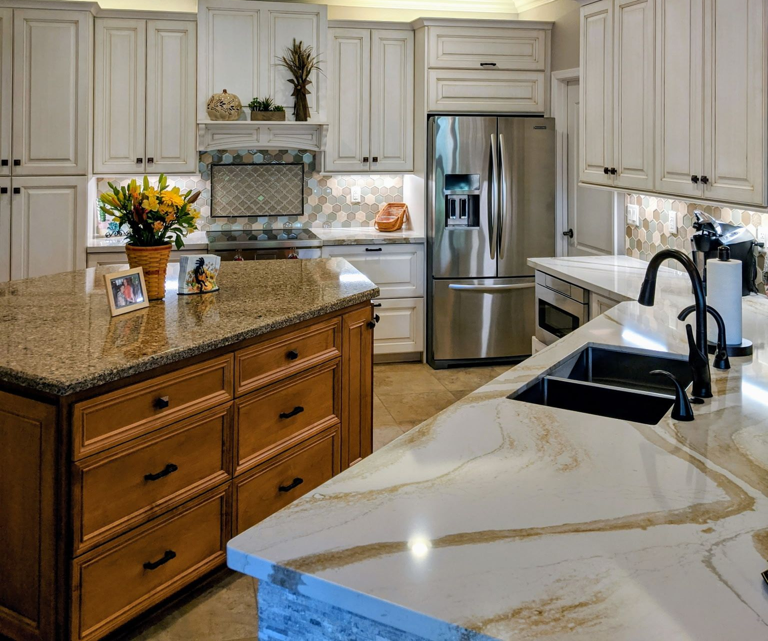 Kitchen with two islands and white cabinets. Stainless steel appliances, and granite countertops.