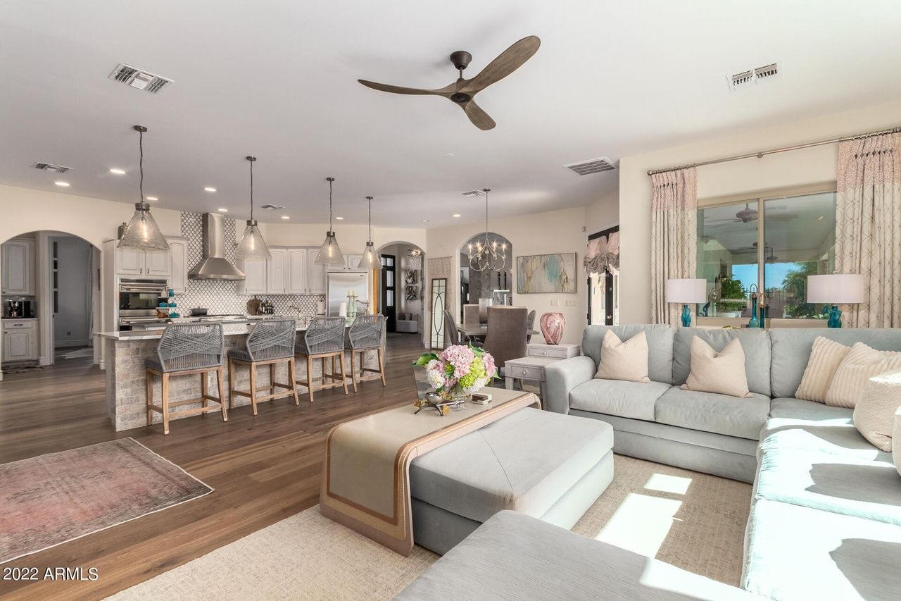 Open-concept living area with kitchen, light blue sectional, and neutral color scheme.