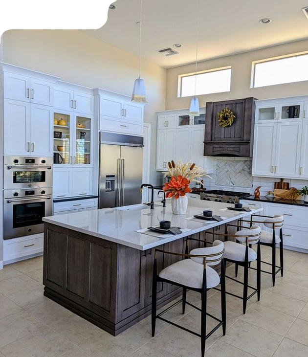 Spacious white kitchen with a large dark wood island and seating, stainless steel appliances, and accent lighting.