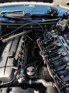 Damaged car engine with intake manifold removed, exposing rusted cylinder openings and greasy metal parts. | Retana's Auto Repair LLC