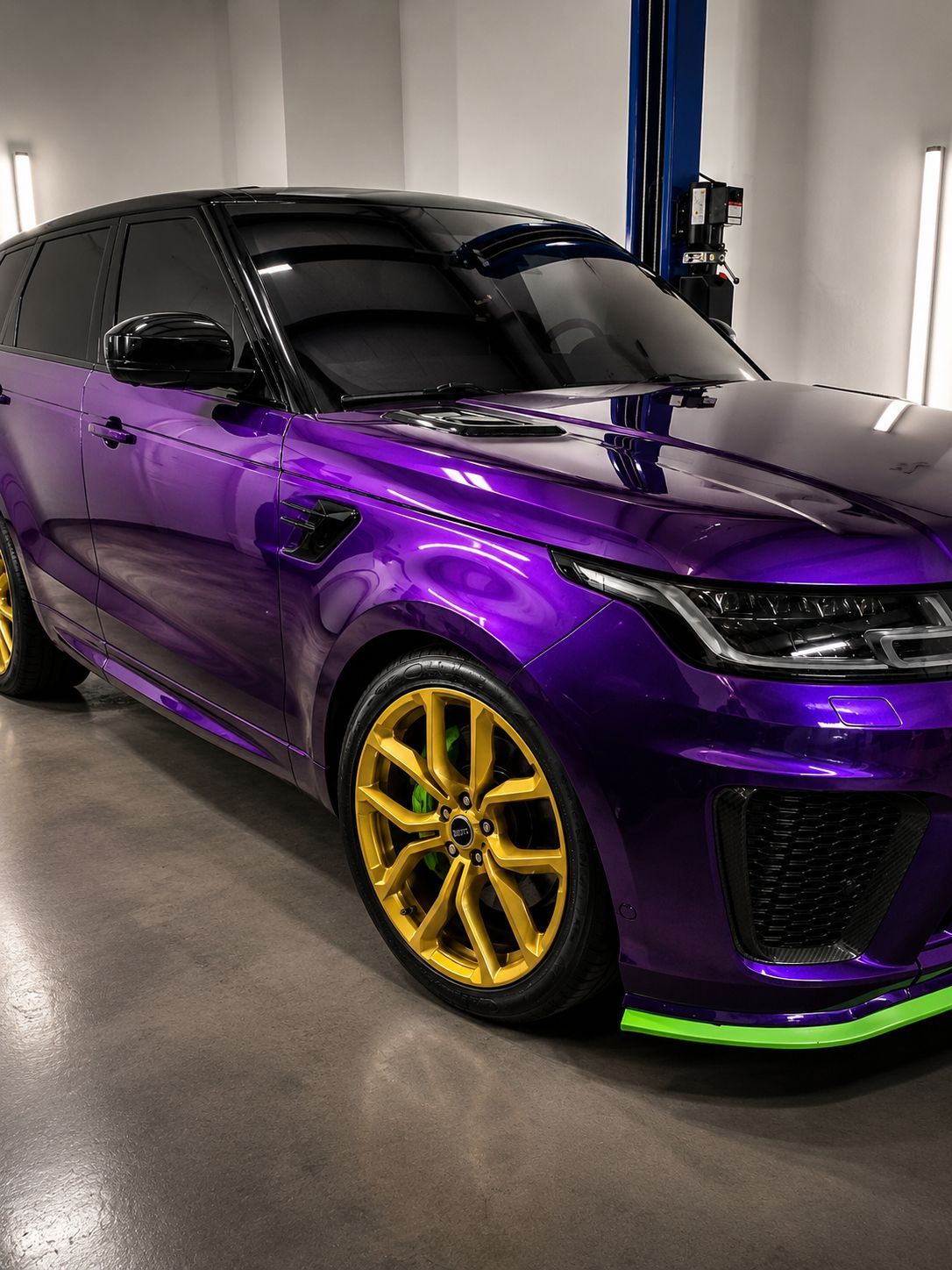Purple sports car with gold rims in a garage, seen from the front side.