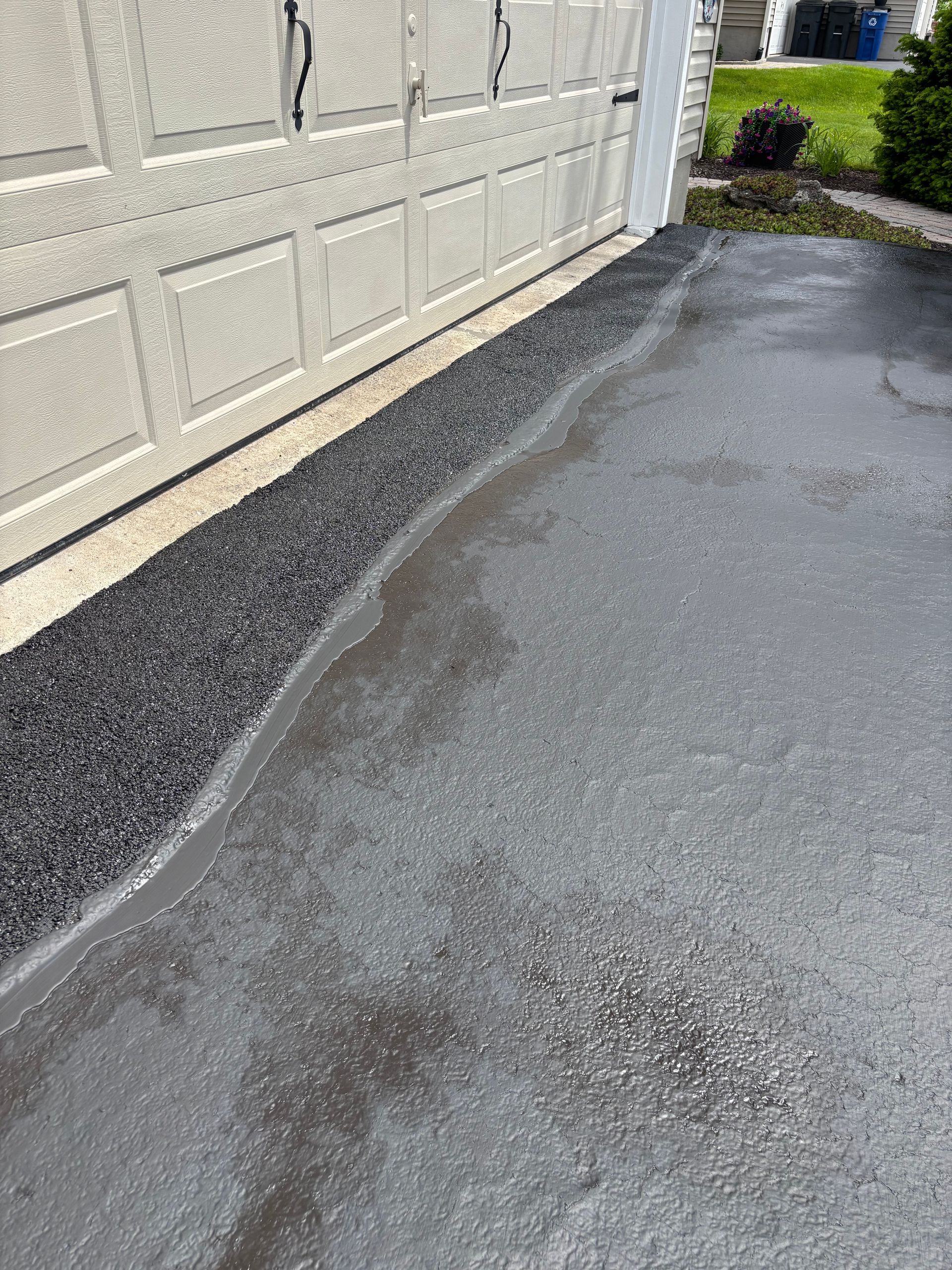 A close up of a driveway next to a garage door.