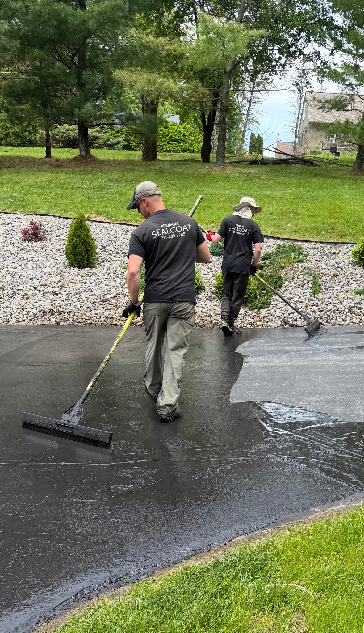 A person is pouring asphalt from a bucket onto the ground.
