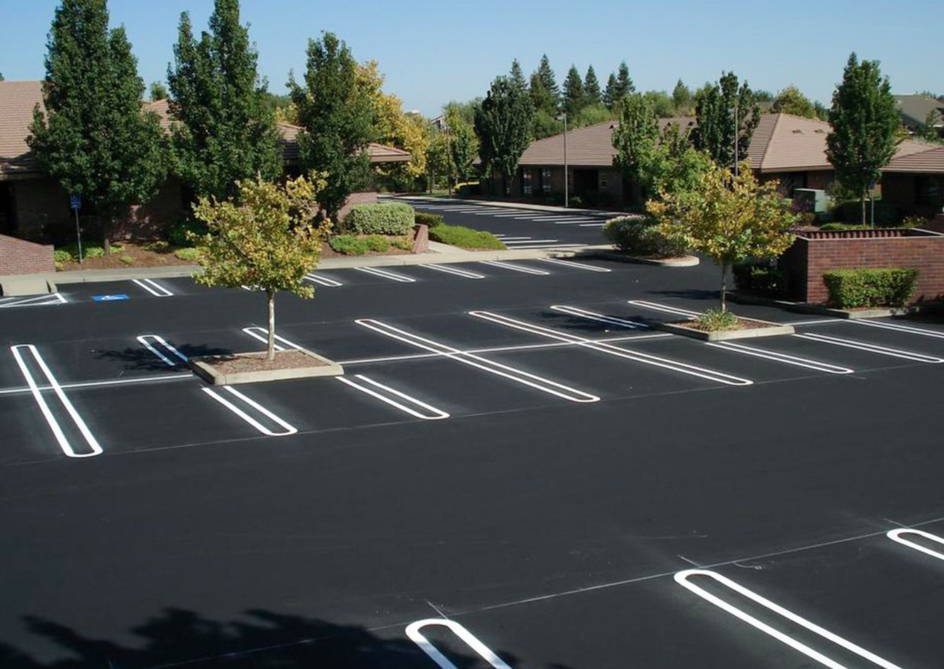 A parking lot with a few houses in the background