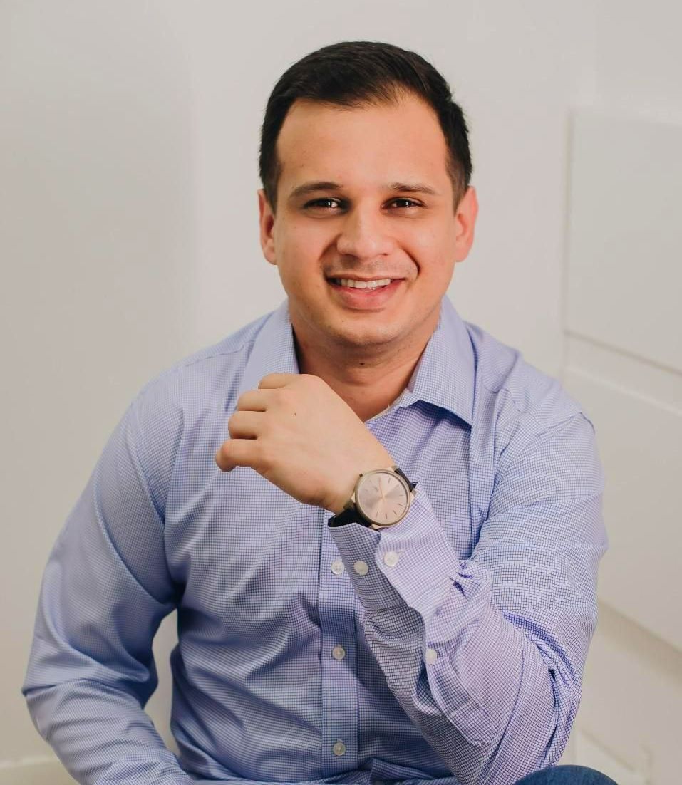 Um homem usando um relógio está sorrindo para a câmera