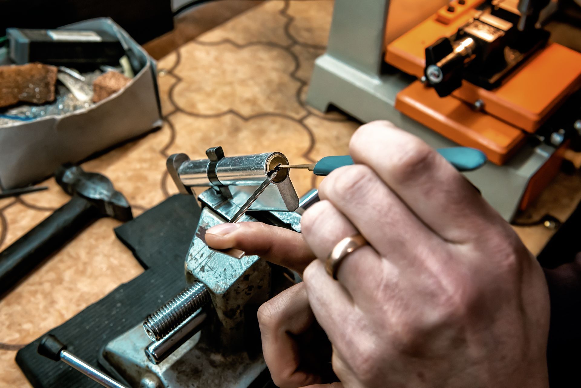 A person wearing a wedding ring is working on a machine.
