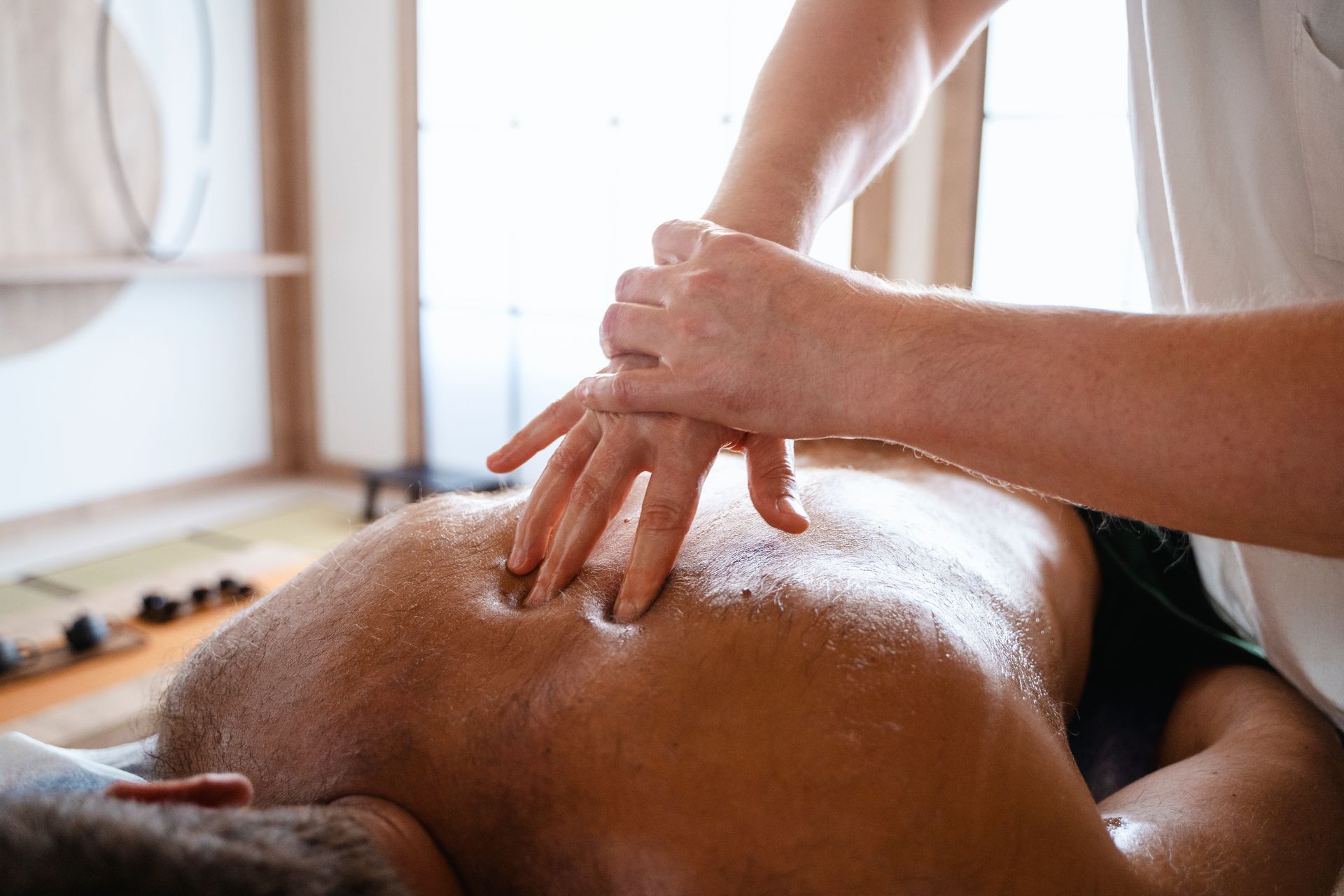 A man is getting a massage from a woman in a spa.