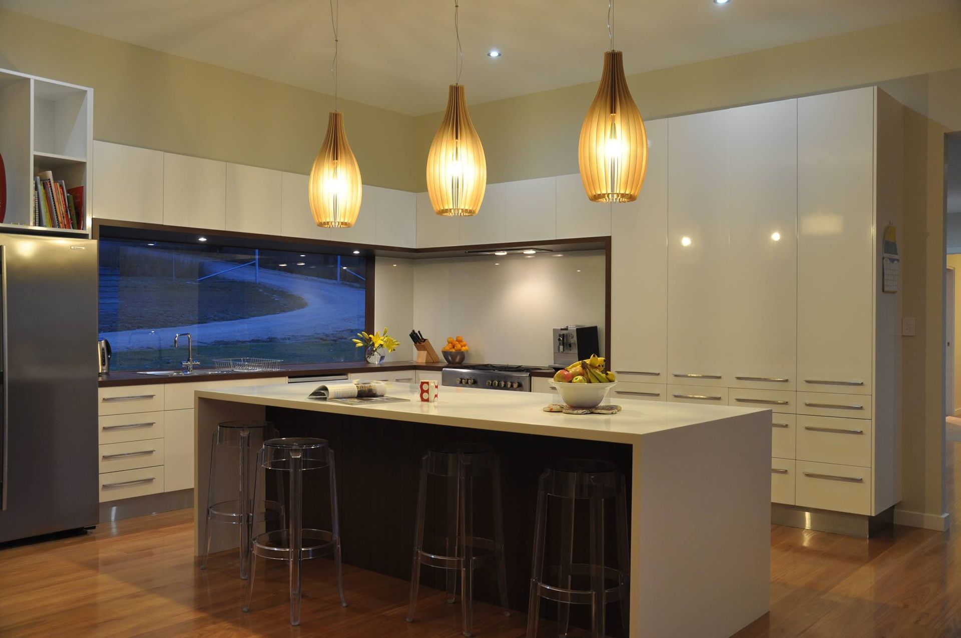 Modern Kitchen With White Cabinets, Island, and Hanging Lights — Level Electrical & Air In Taminda, NSW