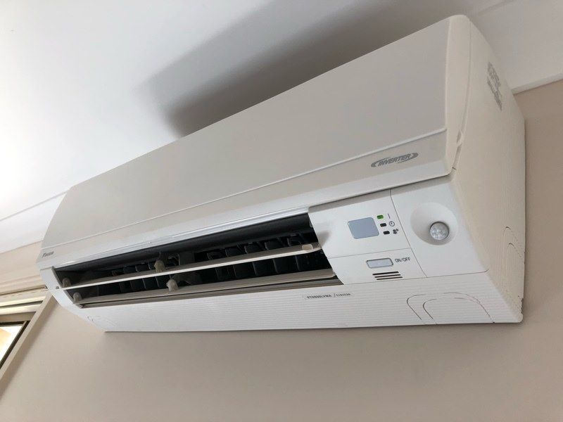 White Air Conditioner Mounted on a Beige Wall — Level Electrical & Air In Taminda, NSW