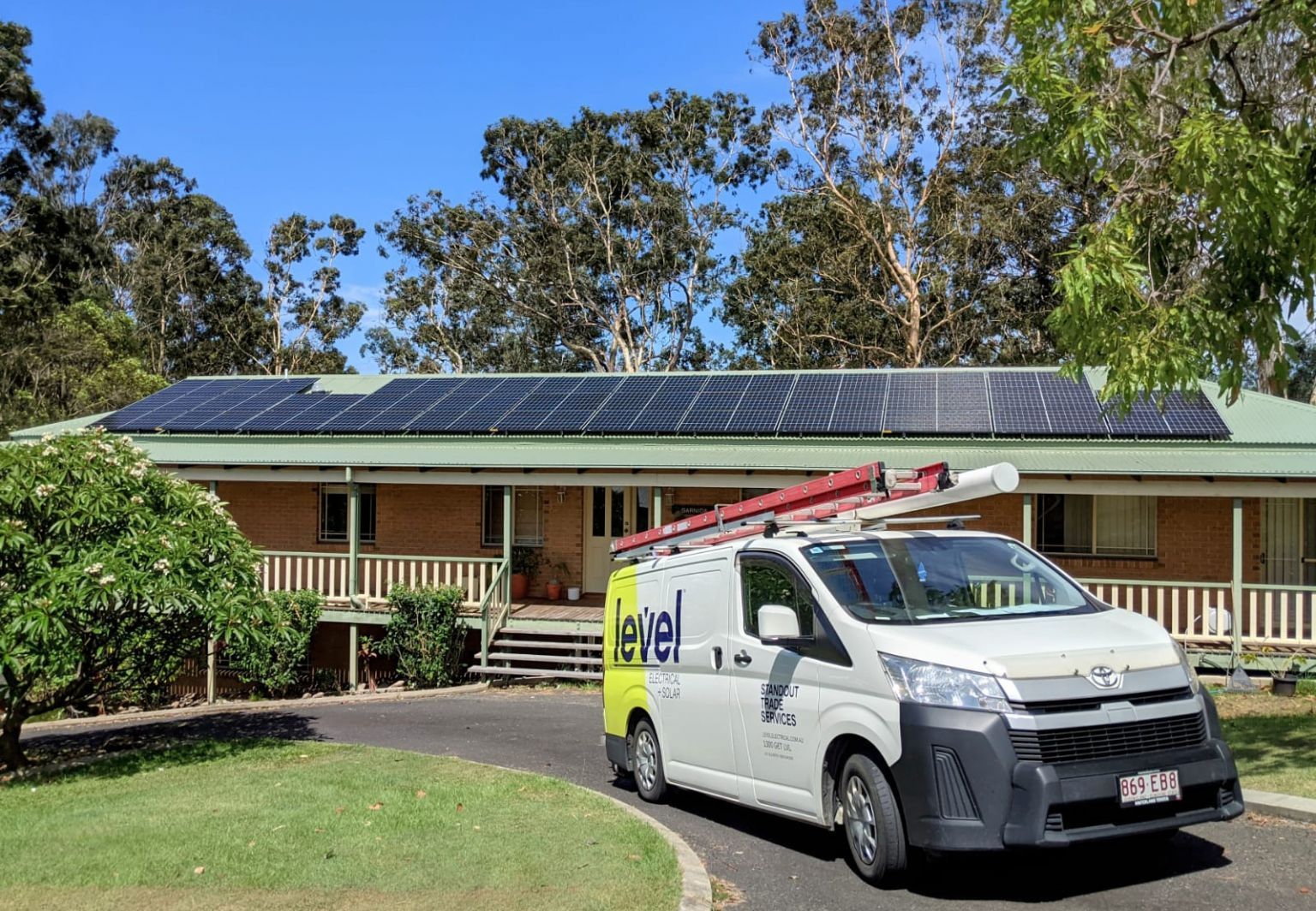 Solar Panels on A House Roof with A Work Van Parked in The Driveway — Level Electrical & Air In Taminda, NSW