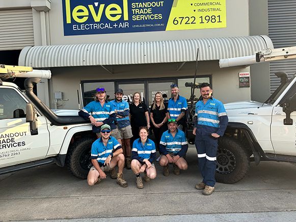 Team of electricians posing outside a Level Electrical & Air service van and storefront — Level Electrical & Air In Inverell, NSW