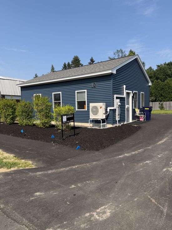 White garage with two doors and gravel driveway on a foggy morning