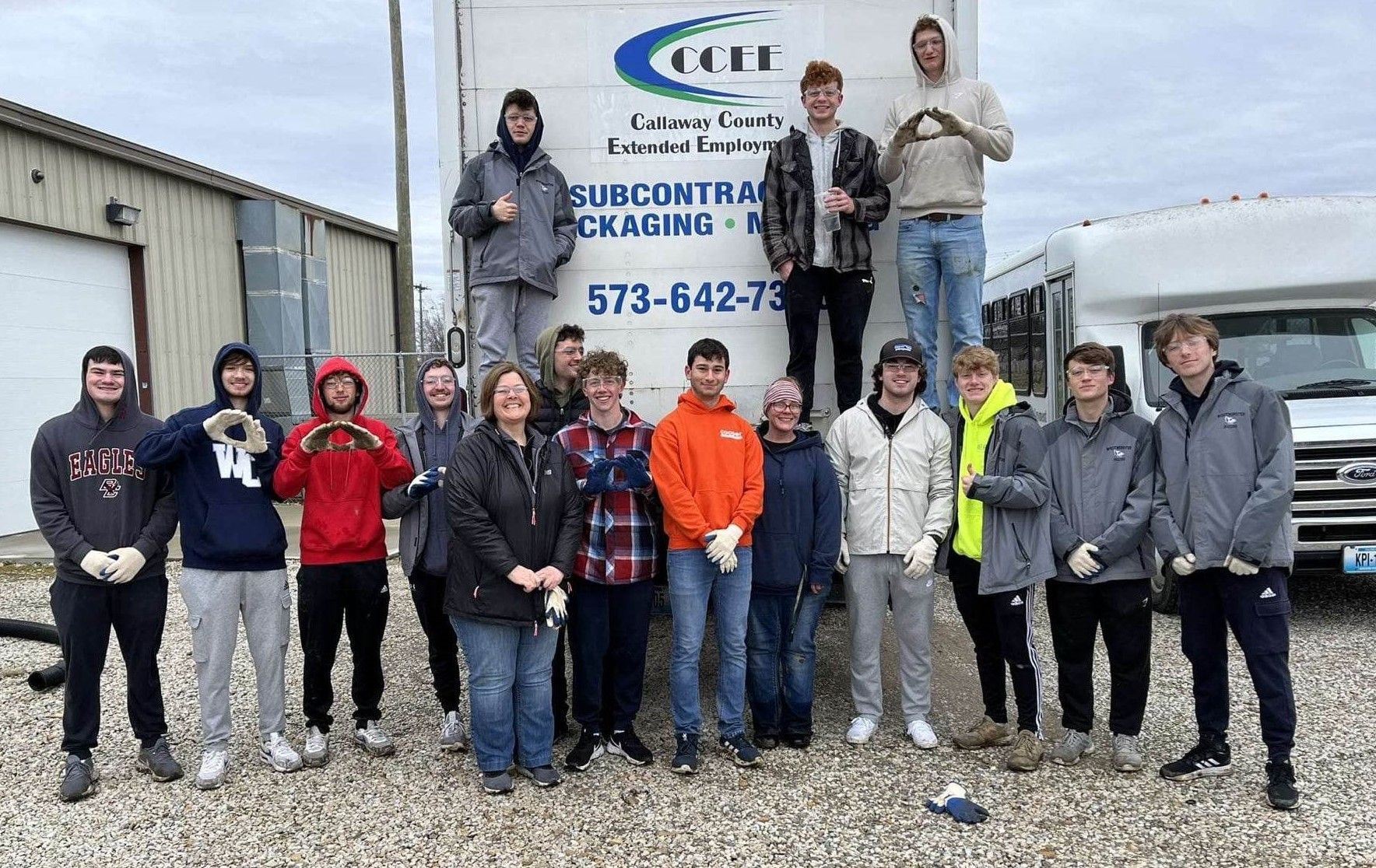 Group of people standing in front of a white truck, likely a work crew, some holding tools. Group of people standing in front of a white truck, likely a work crew, some holding tools.