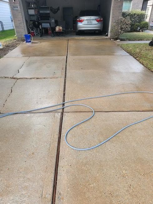 A split-view shot comparing a dirty concrete driveway on the left to a clean, pressure-washed section on the right.