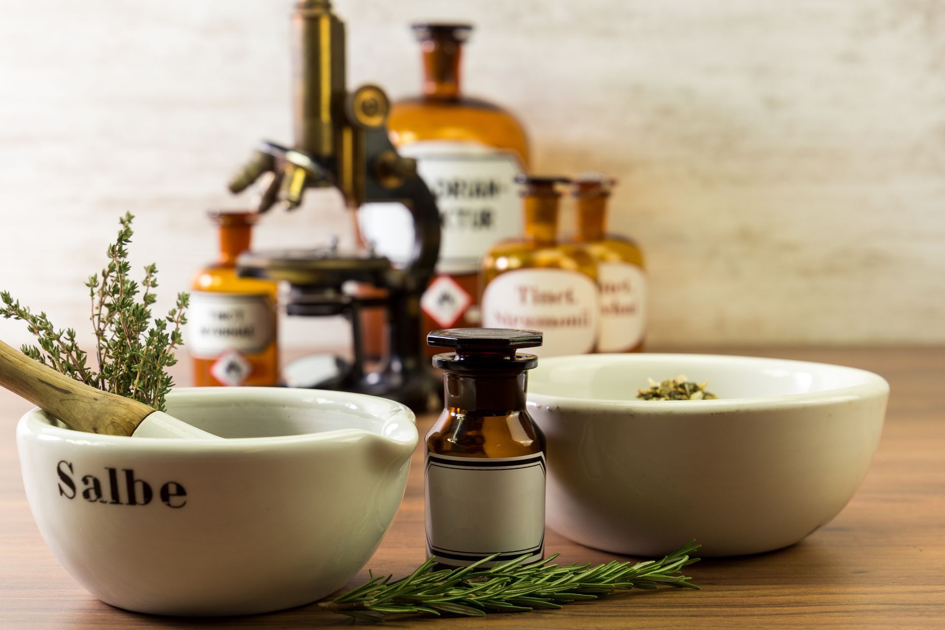 Einrichtung einer Kräuterapotheke: Mörser und Stößel mit Kräutern, Vintage-Flaschen, Mikroskop.