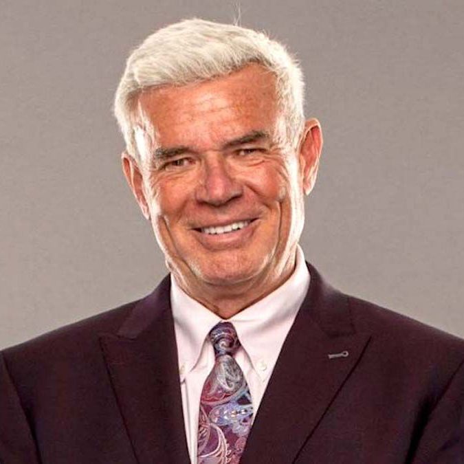 Eric Bischoff smiling in a suit and tie.