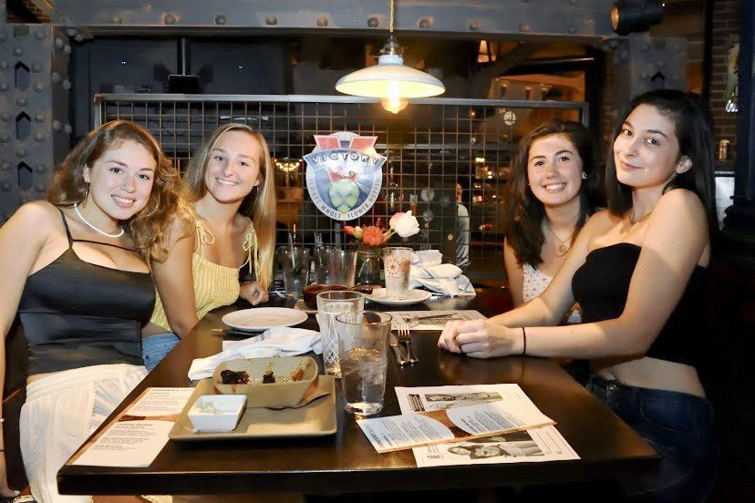 Four people seated at a table in a dimly lit restaurant.