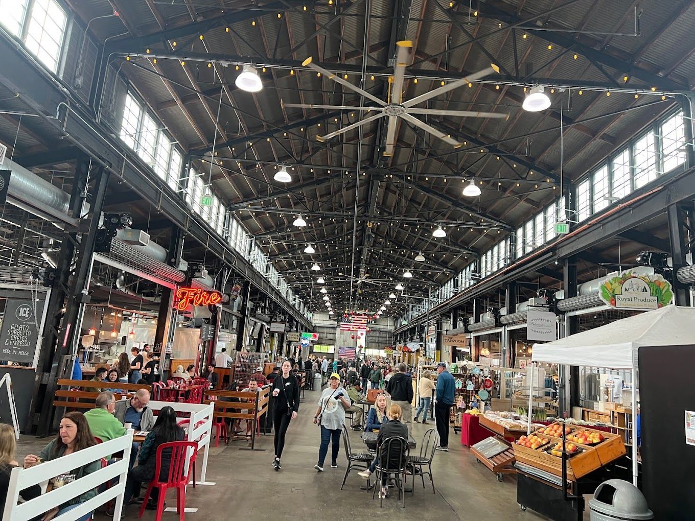 A large indoor market filled with people eating and shopping.