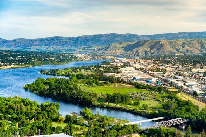 An aerial view of a river surrounded by trees and mountains.