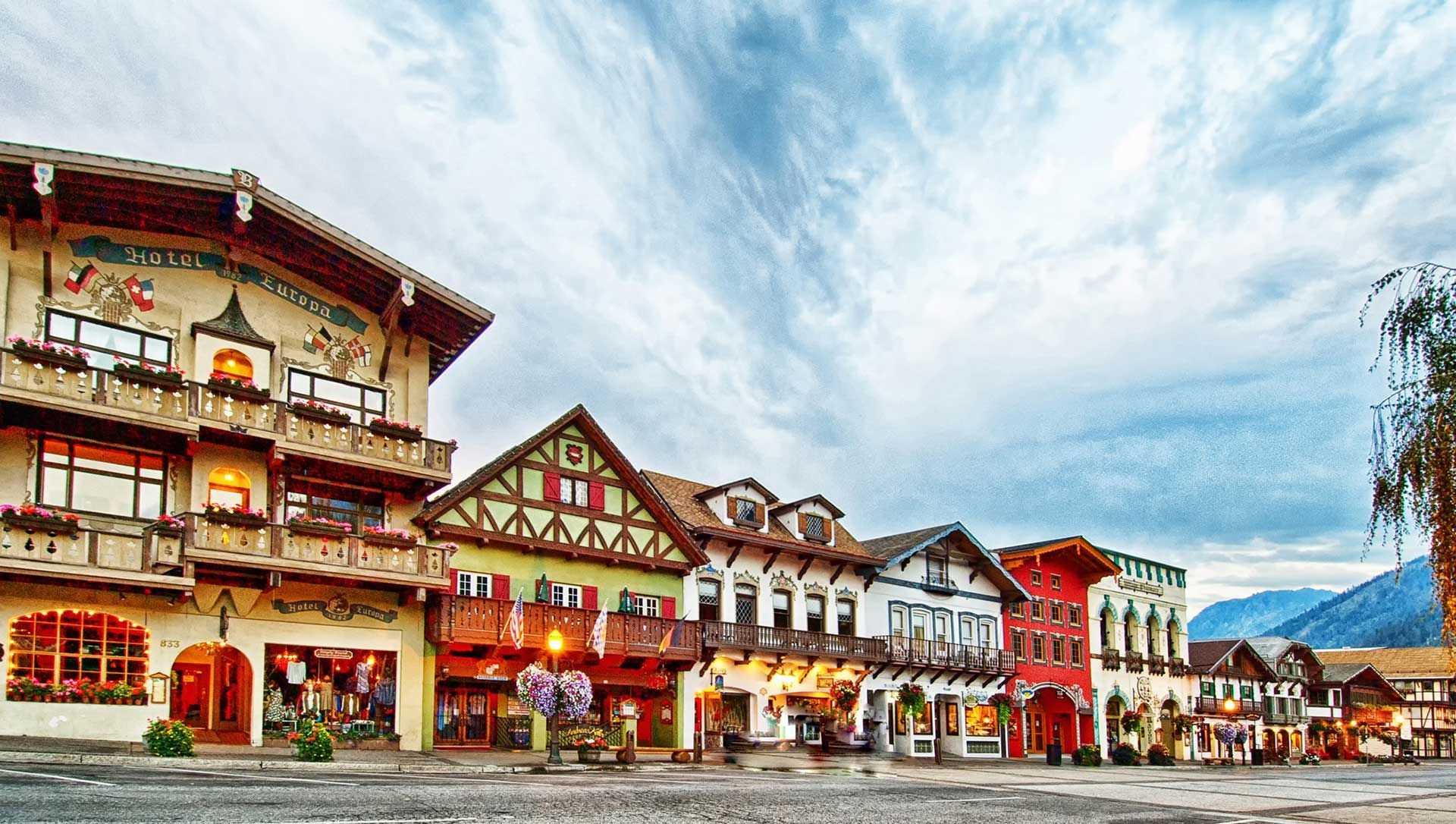 A row of houses in a small town with mountains in the background.