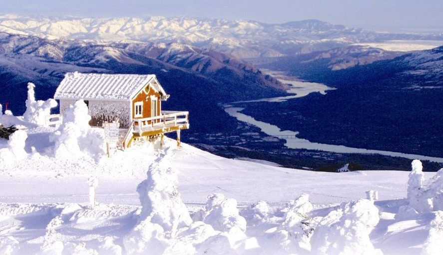 A small cabin on top of a snow covered mountain