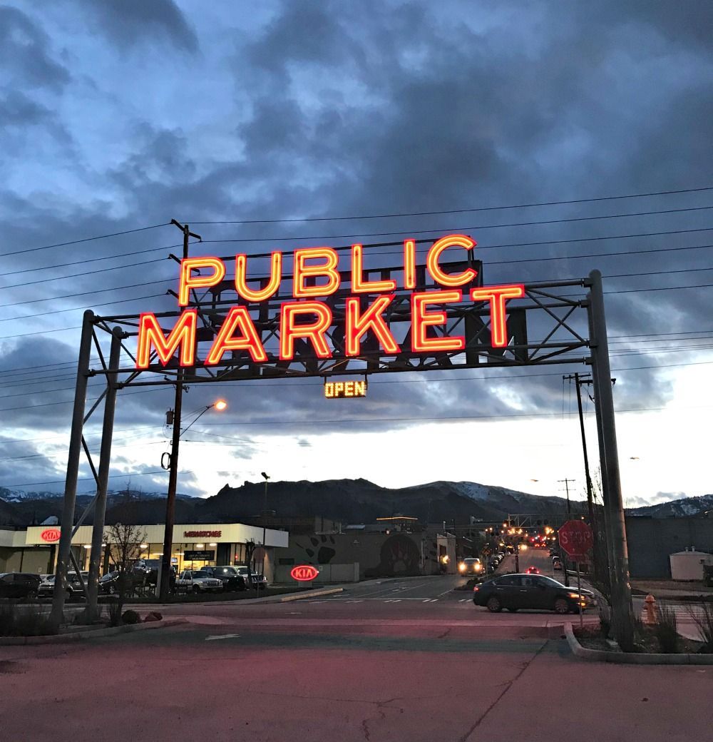 A sign for the public market is lit up at night