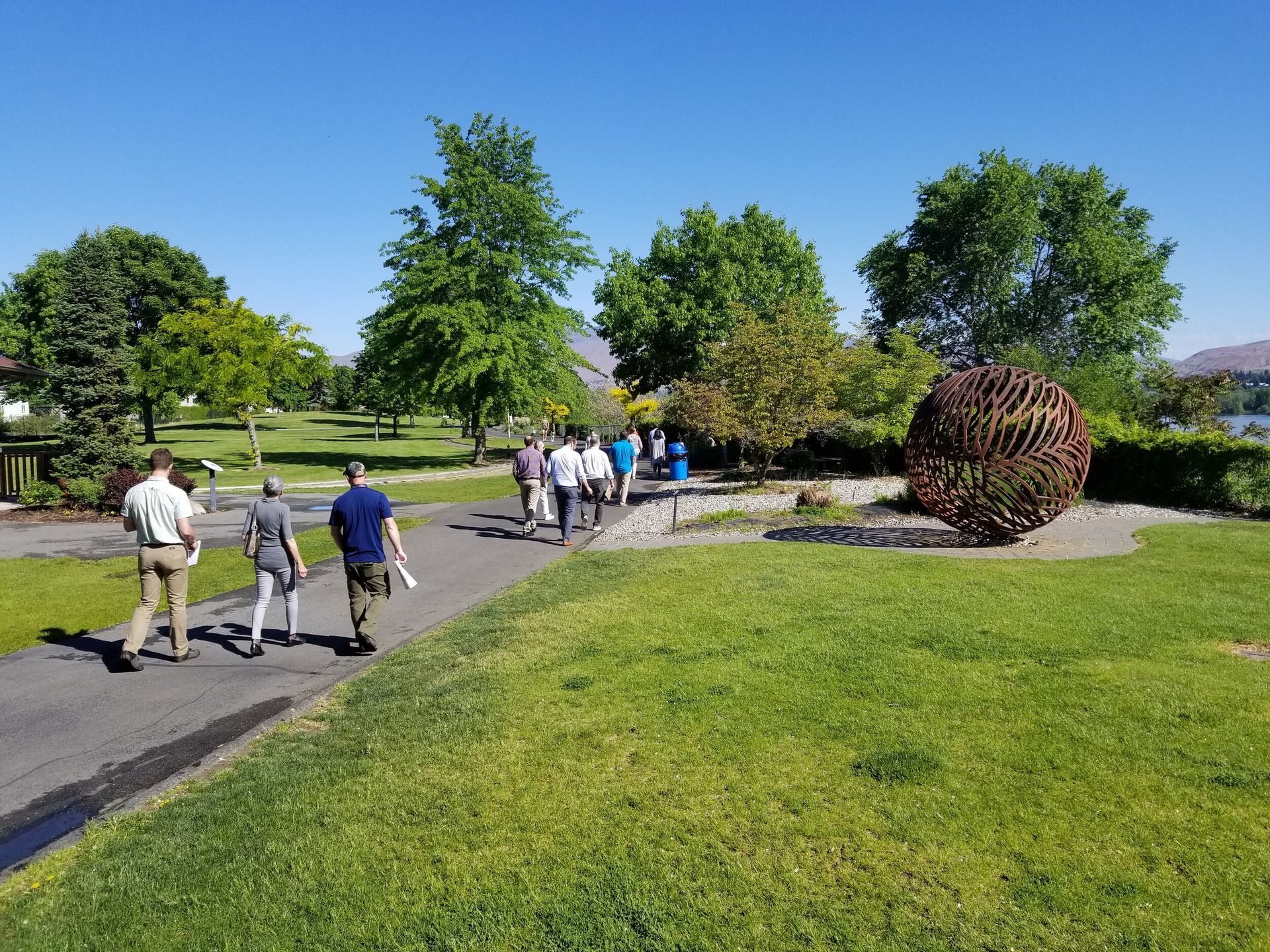 A group of people are walking down a path in a park.