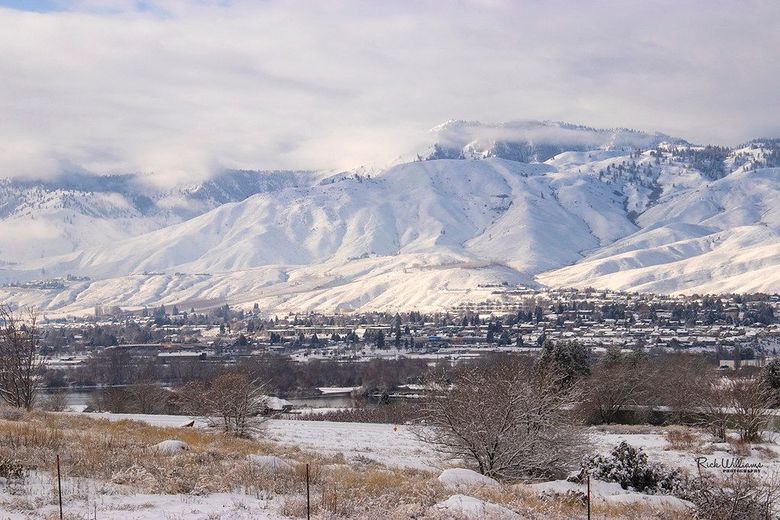 A snowy mountain range with a small town in the foreground