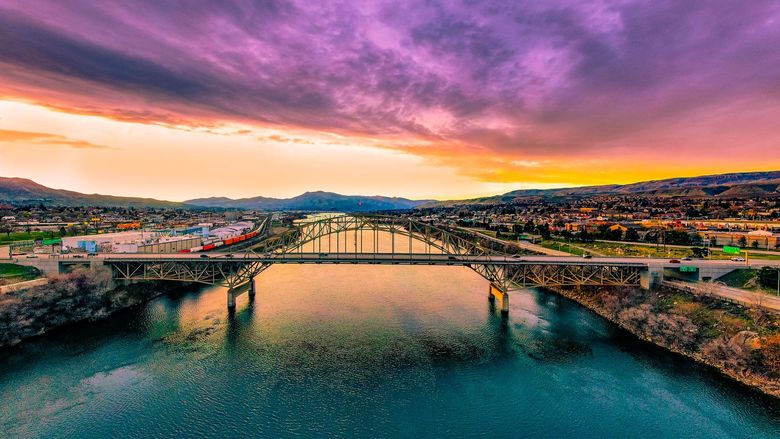 An aerial view of a bridge over a river at sunset.