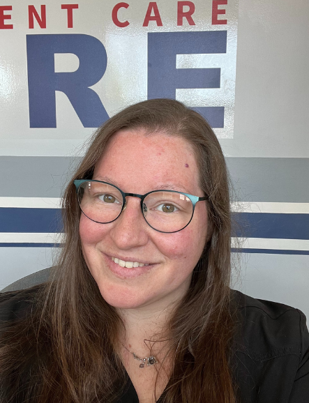 A woman, Kaitlin Patchett, wearing glasses is smiling in front of a sign that says ent care re